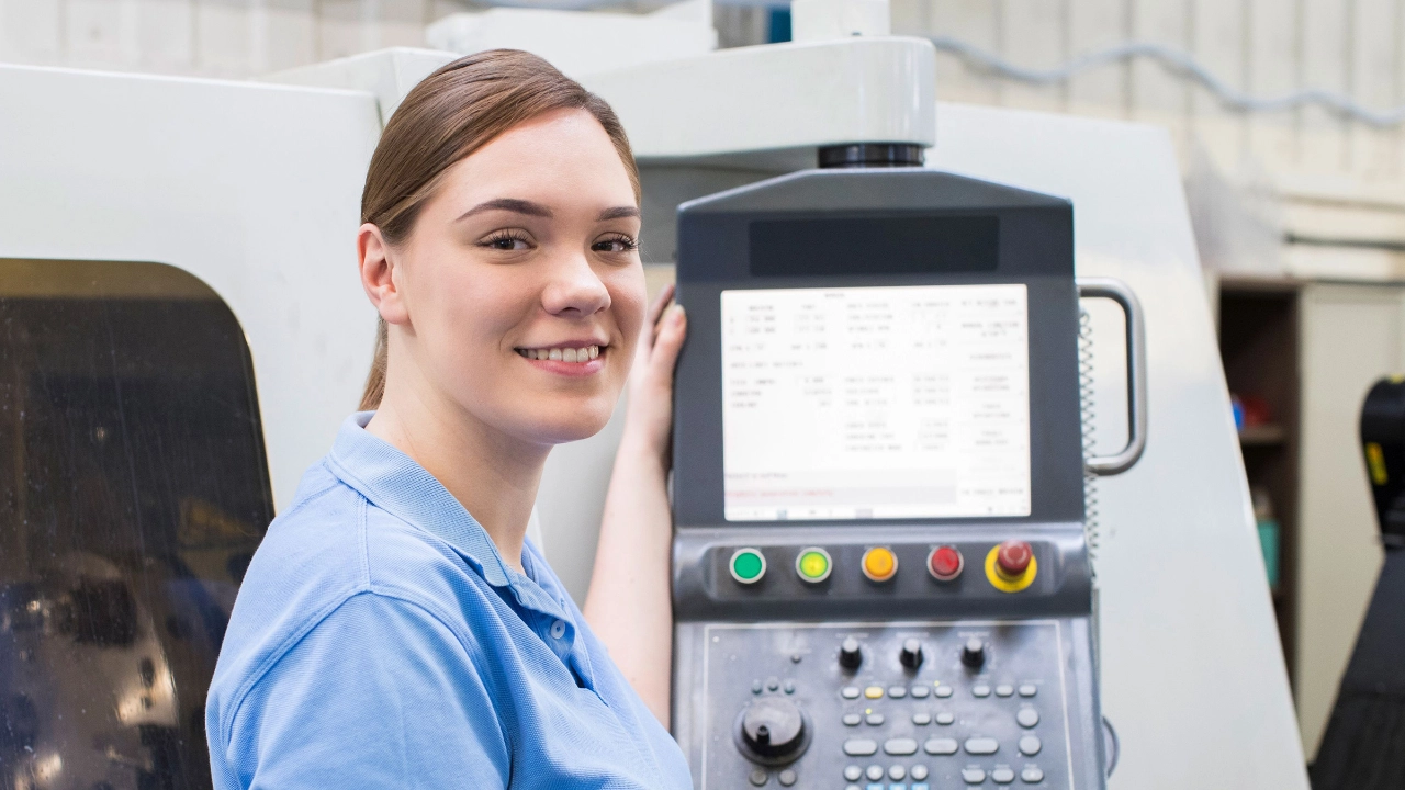 Facharbeiterin an einer CNC-Maschine