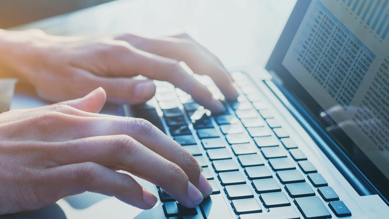 Mensch schreibt an einem Laptop