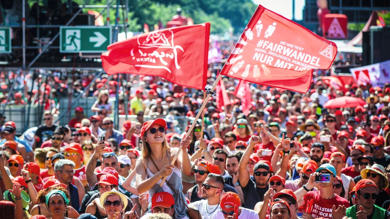 junge Metallerin weht Fahne auf FairWandel-Kundgebung in Berlin 2019