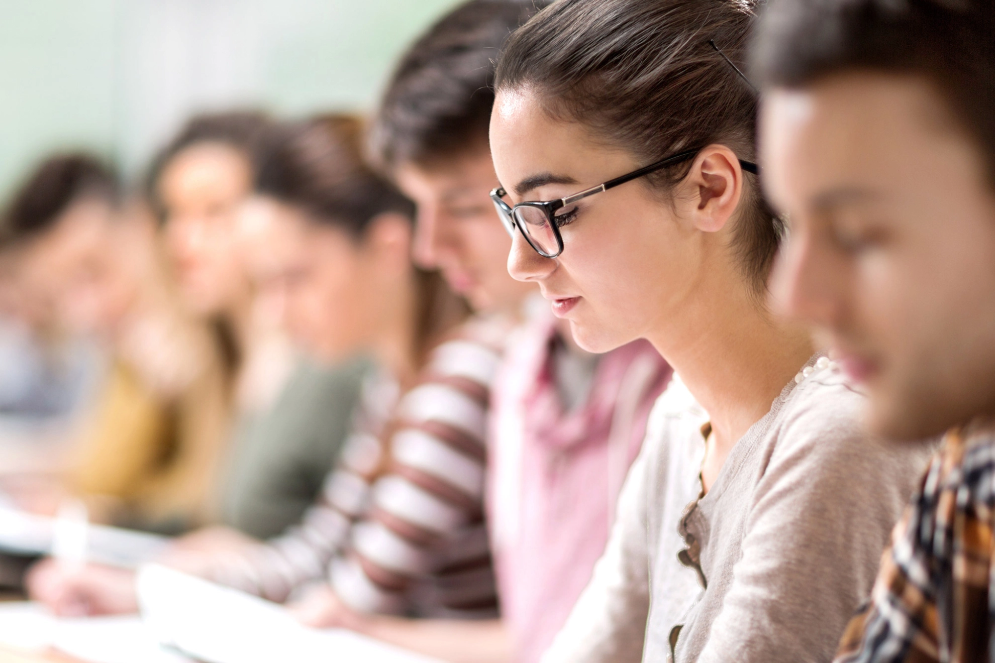 Eine Studentin schaut während eines Seminars auf ihre Notizen.
