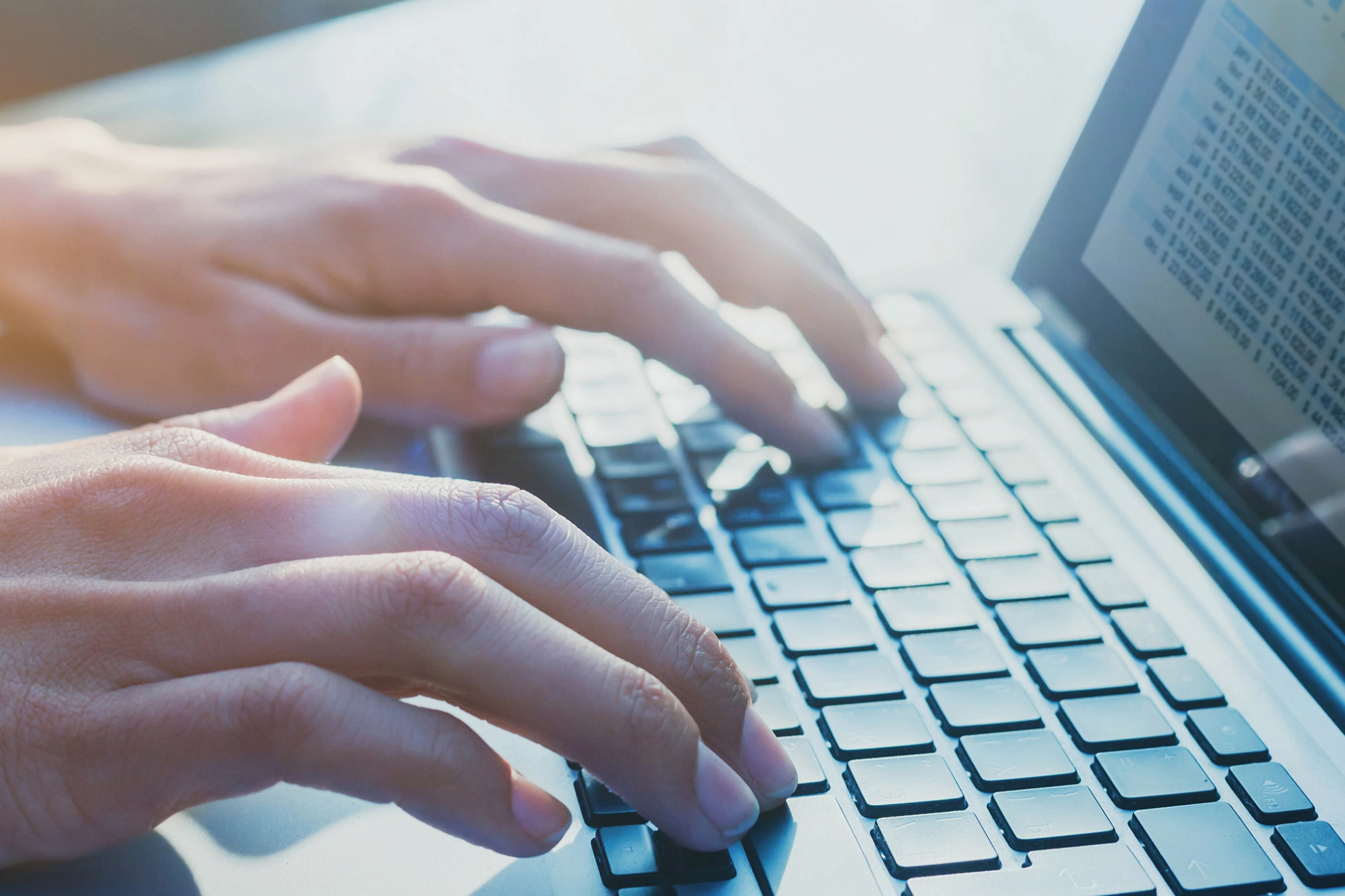 Mensch schreibt an einem Laptop
