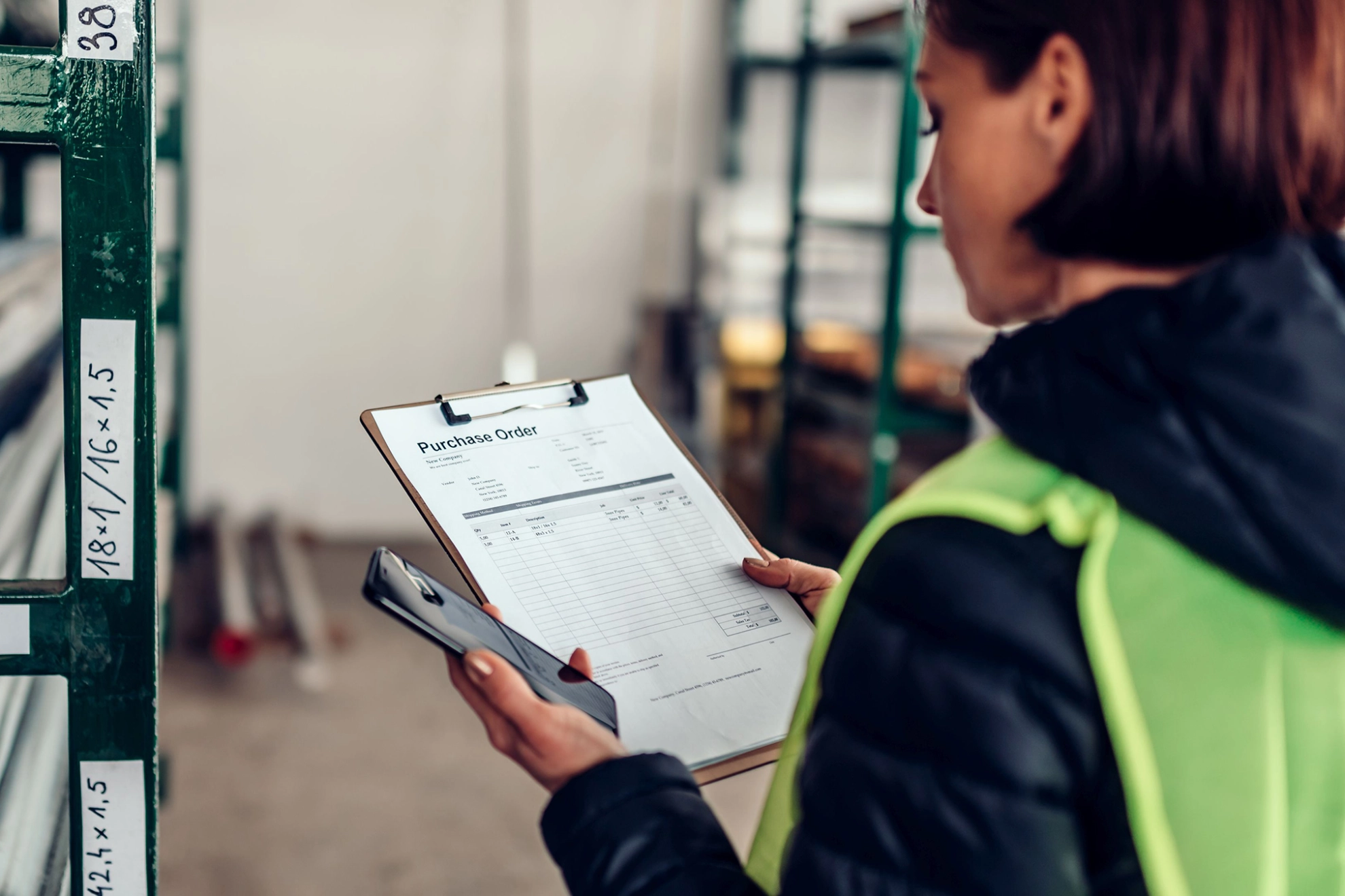 Arbeiterin prüft im Materiallager einen Auftrag
