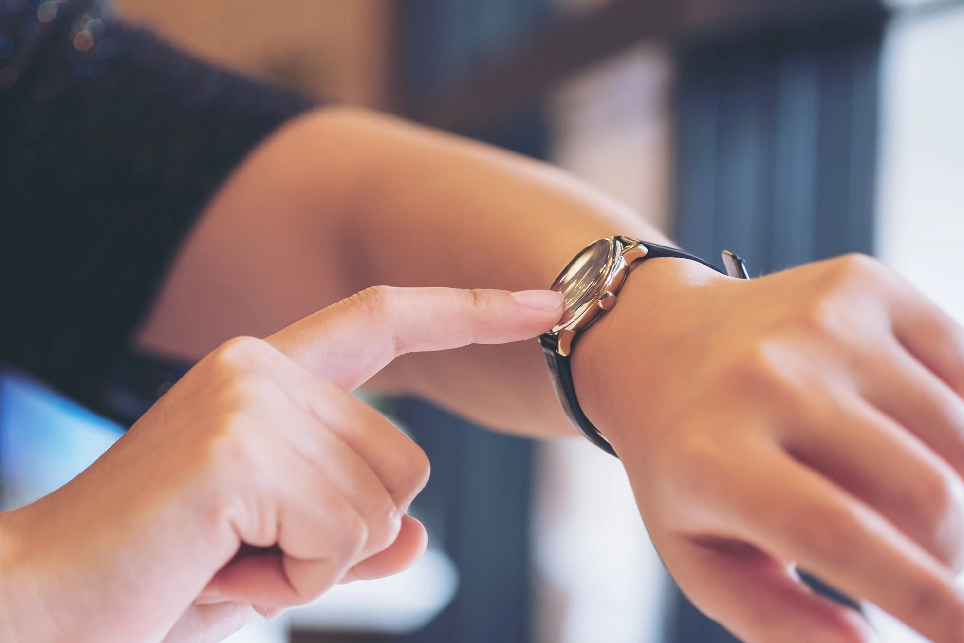 Eine Frau zeigt auf ihre Armbanduhr