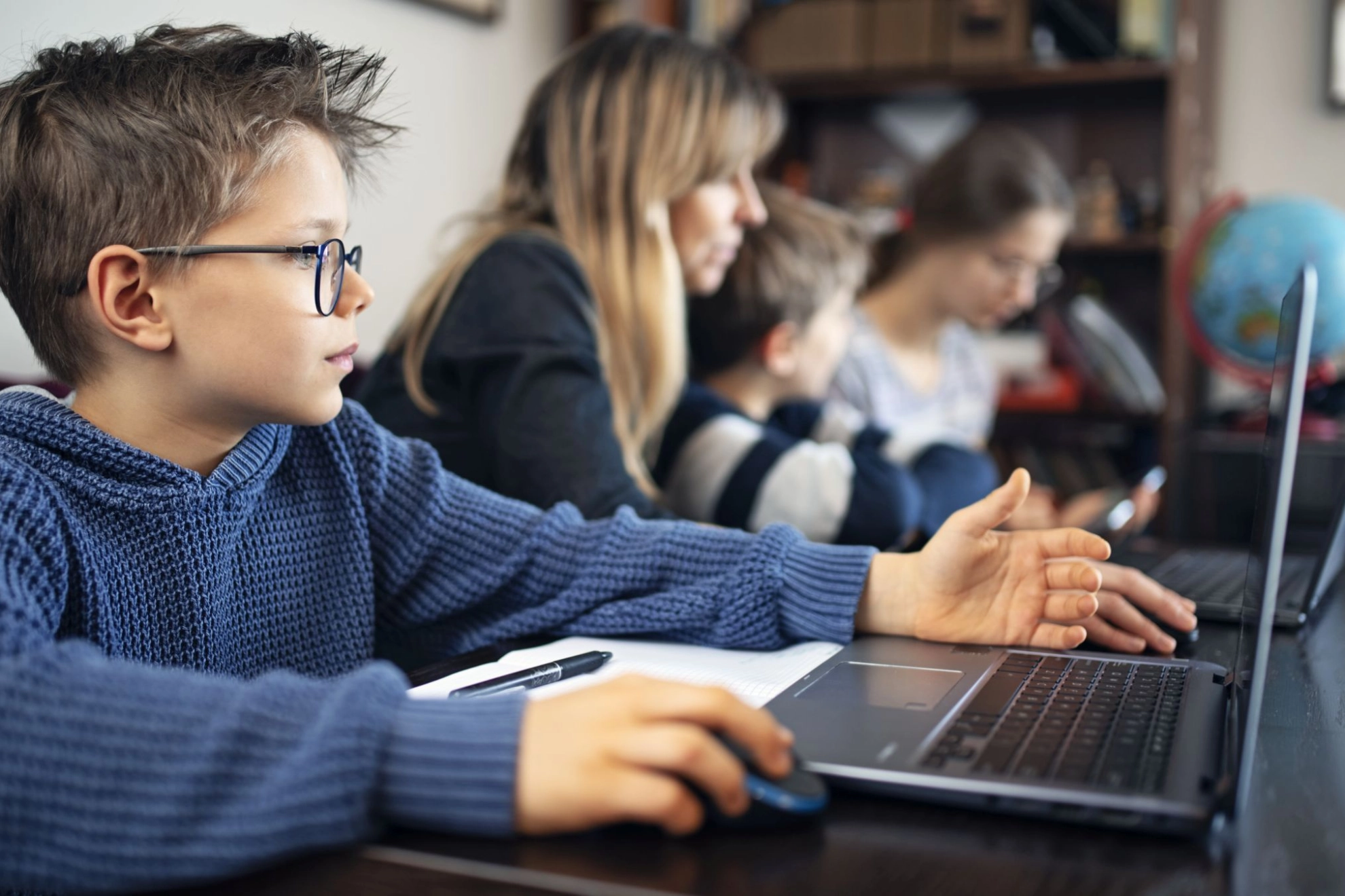 Mutter mit Kindern im Homeoffice und Homeschooling