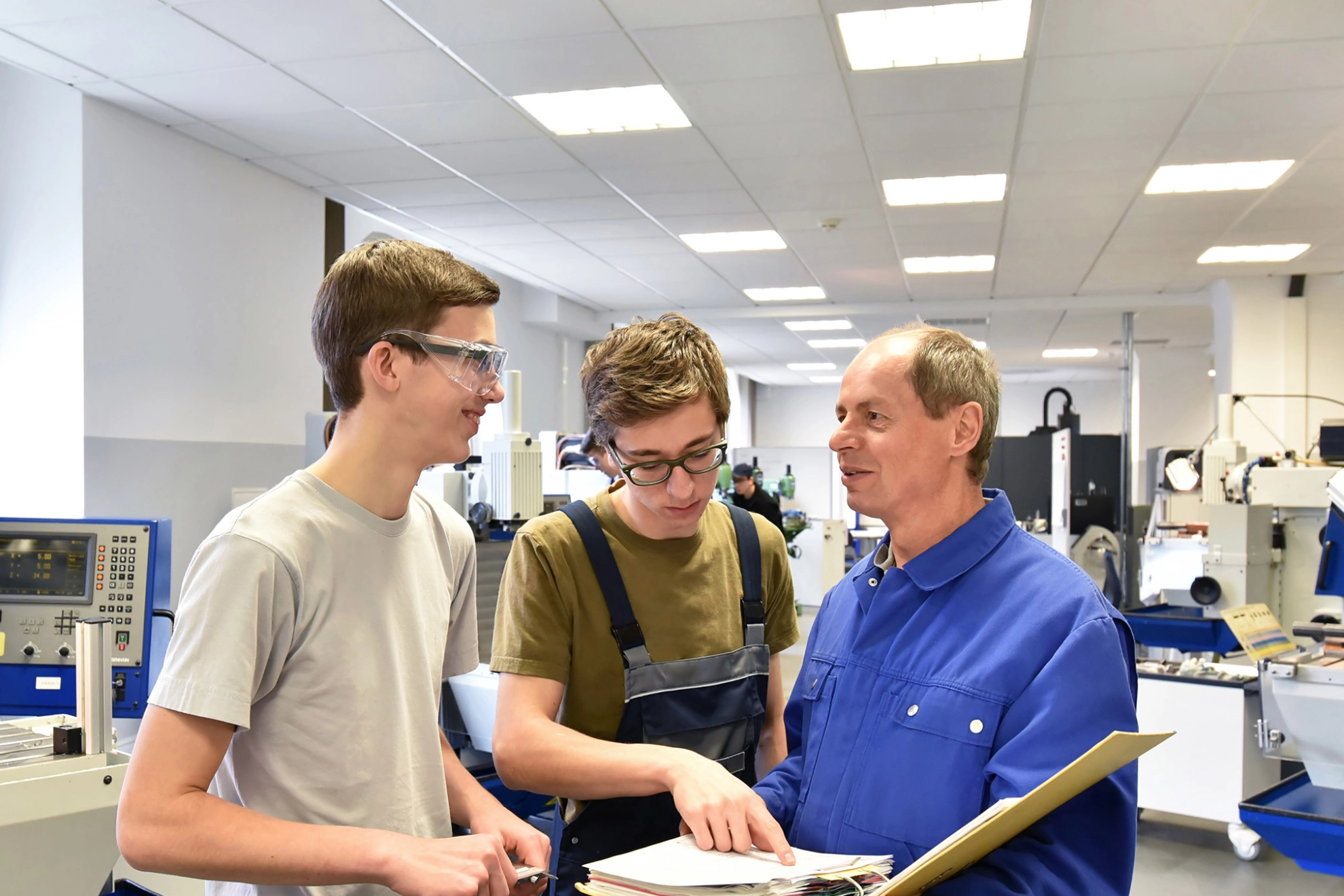 Gruppe von Jugendlichen in der technischen Berufsausbildung mit Lehrer