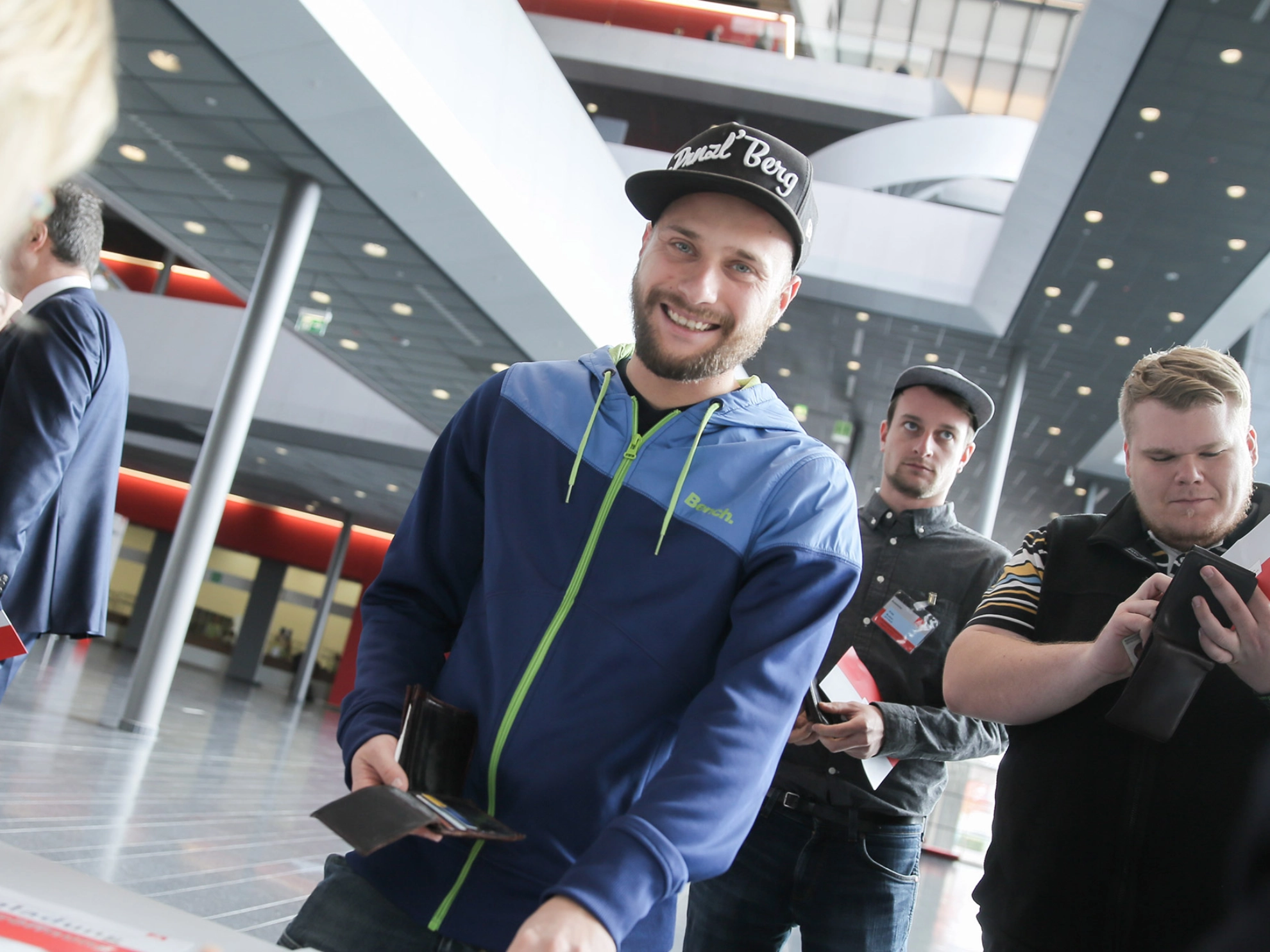 Ein junger Mann mit schwarzer Kappe und Hoodie an eine Infostand.