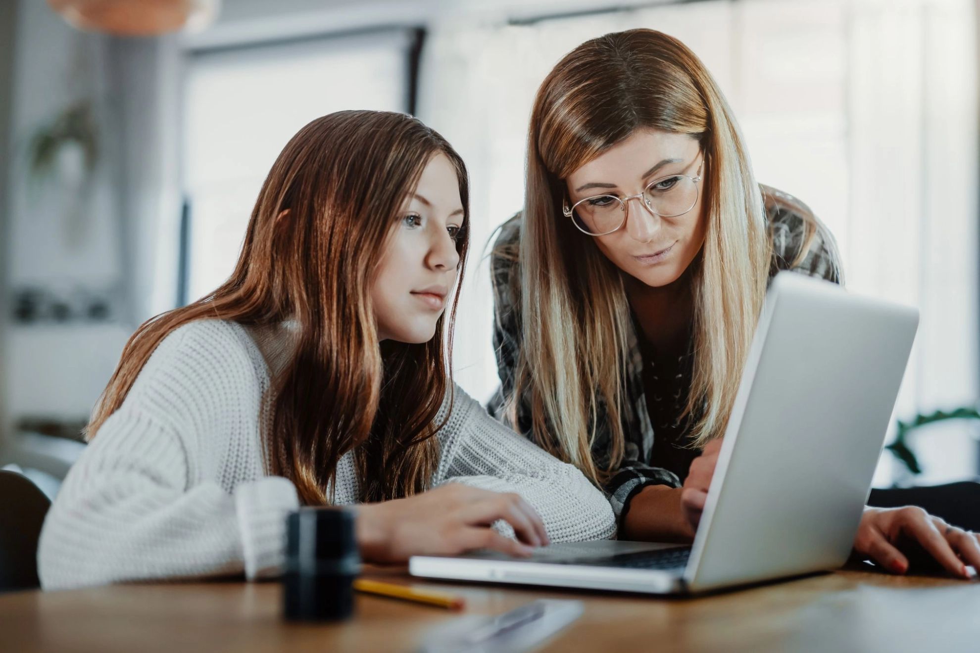 Mutter und Tochter schauen gemeinsam auf einen Laptop