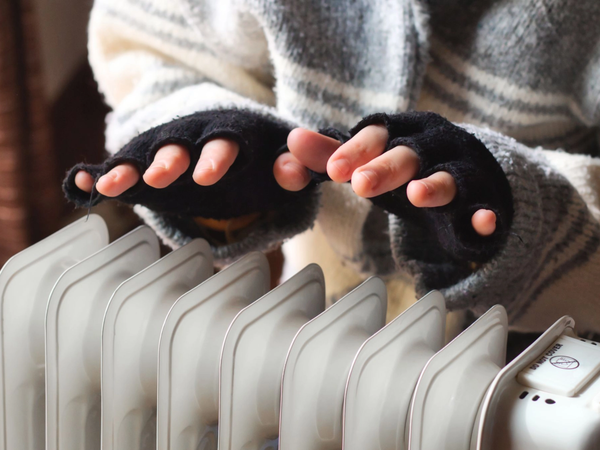 Hände über Heizkörper wärmen