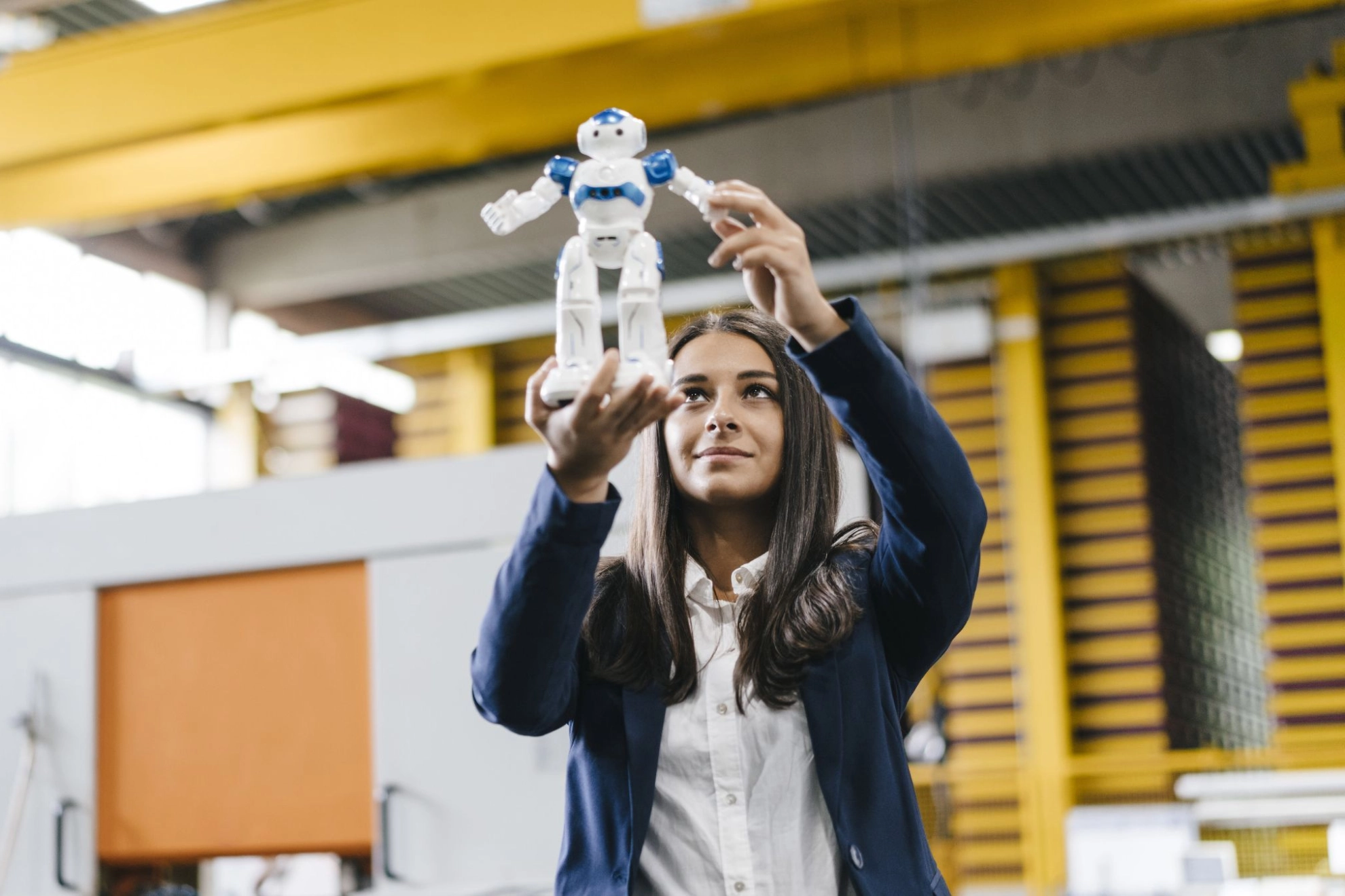 Junge Frau hält Mini-Roboter vor sich