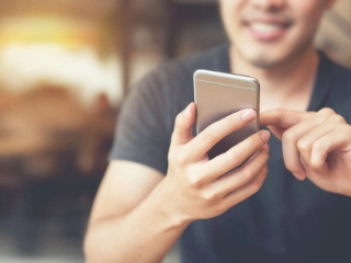 junger Mann bedient ein Smartphone