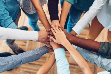 Eine Gruppe von Menschen stapeln ihre Hände