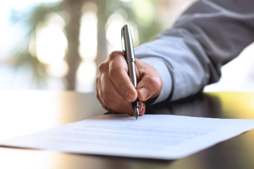 Person unterschreibt ein Dokument