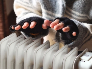Hände über Heizkörper wärmen