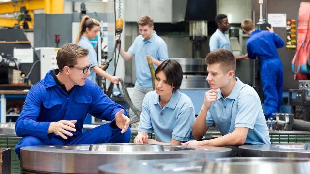 Drei Arbeitnehmer im Gespräch am Arbeitsplatz